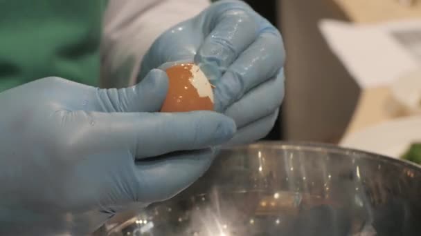 Cook hands clean eggshell from egg for cooking in restaurant kitchen close up — Stock Video