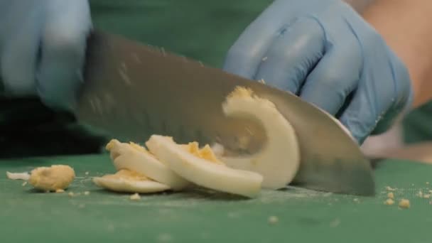 Chef cocinero cortar huevo en rodajas a bordo en restaurante cocina de cerca — Vídeos de Stock