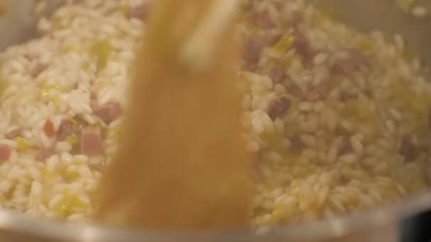 Mixing rice with vegetables and meat while cooking risotto in italian restaurant — Stock Video