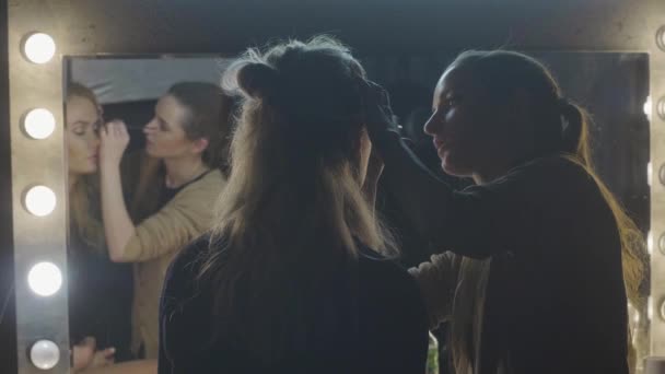 Visagistin macht Mode-Make-up auf Frau Gesicht vor Spiegel im Schönheitssalon — Stockvideo