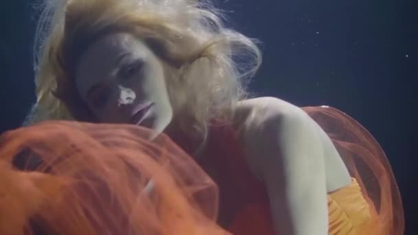 Attractive woman in orange dress underwater in swimming pool — Stock Video