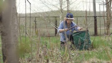 Bahçe arka bahçesinde çalışan yaşlı bahçıvan kadın. Mevsimlik Bahçe içinde temizlik