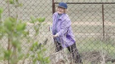 Bahçede çalışan ve toprak kazma mutlu kadın kıdemli