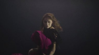 Şehvetli kadın yüzme havuzunda su altında yüzmek ve video çekimleri için poz şifon elbise