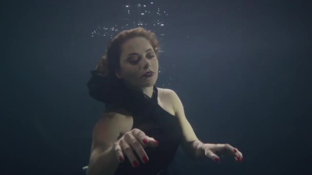Esmer kadın sualtı yüzme havuzu koyu arka plan üzerinde — Stok video