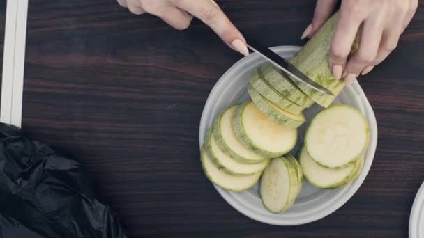 Hembra manos de corte con cuchillo de médula vegetal en placa en la mesa vista superior — Vídeo de stock