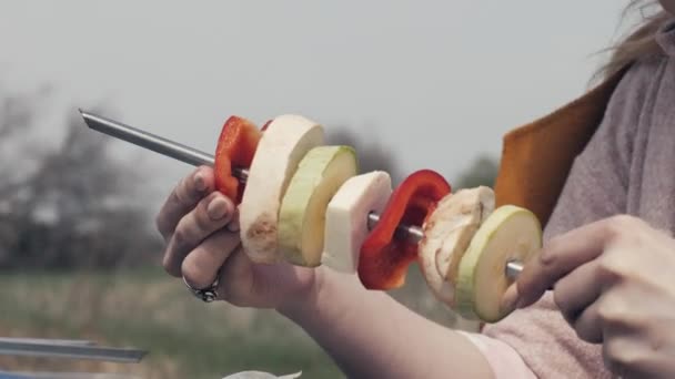 Mãos femininas amarrando vegetais no espeto no churrasco para piquenique ao ar livre — Vídeo de Stock