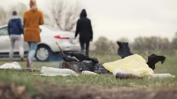 Grupo de jóvenes dejando basura, botellas y fuego sin inspiración después del picnic — Vídeo de stock