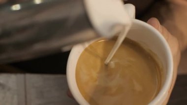 Barista kahve ve kapuçino kalp ile köpük yapım dökülen süt yakın çekim