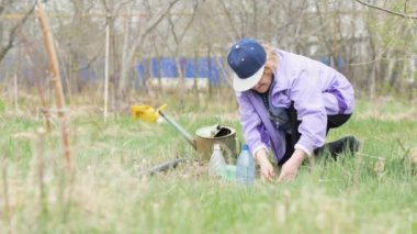 Portre bahçıvan kadın bakım bahçede çalışırken çiçek fide hakkında