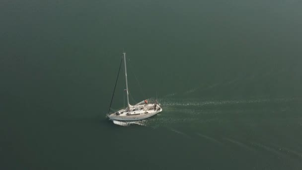 Jacht aus der Luft, die auf offener See segelt. Drohnenblick auf im Meer schwimmendes Boot. — Stockvideo