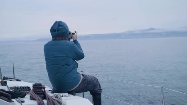 Člověk dělat fotografie krajiny během námořní plavba na plující lodi zadní pohled — Stock video