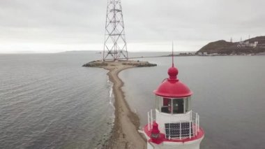 İn üstünden uçan uçak deniz feneri ve iletişim kulesi deniz kenarı göster