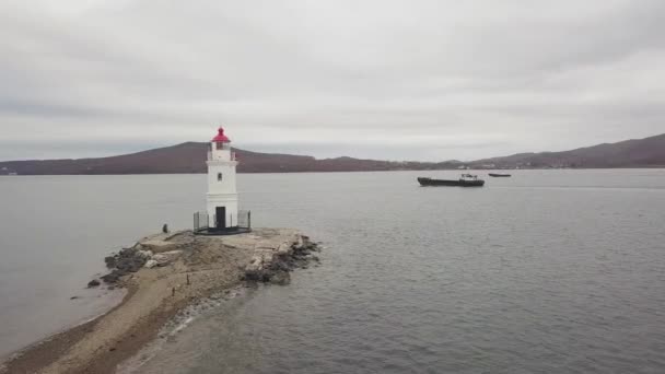 Drone view freighter ship and sea lighthouse on mountain and skyline background — Stock Video