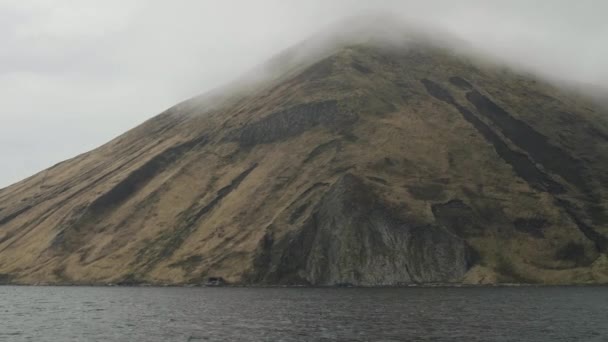 Alta montaña en el mar y nubes de niebla en la parte superior vista desde el barco de vela en el mar — Vídeos de Stock