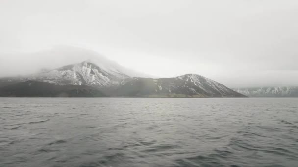 Vista sobre montaña con picos nevados y mar. Barco de mar navegando más allá de montaña nevada — Vídeos de Stock