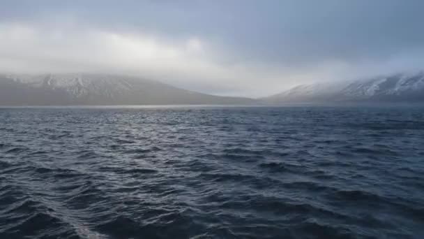 Mavi deniz ve bulutlu gökyüzü arka plan karlı zirveleri ile panoramik dağ — Stok video