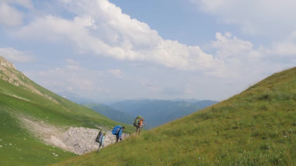 Túrázás az emberek sétálni a hegy, a háttérben zöld dombok és a Felvidéken — Stock videók