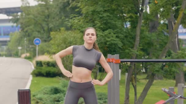 Fitness femme faire échauffement exercices sur la formation en plein air . — Video
