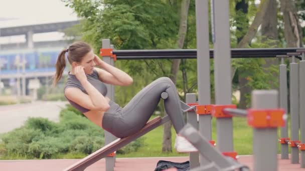 Hermosa chica entrenamiento ejercicio en el campo de deporte en el parque de verano — Vídeos de Stock