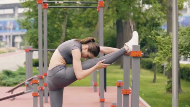 Fitness-Frau macht Dehnübungen bis zu den Beinen beim Outdoor-Training