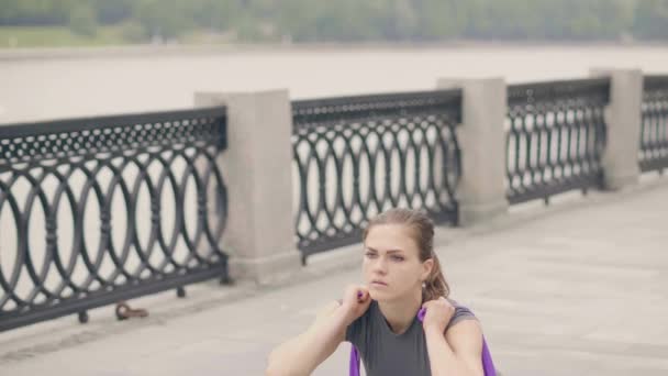 Fitness mujer entrenamiento en cuclillas ejercicio con expansor deportivo en el entrenamiento al aire libre — Vídeos de Stock