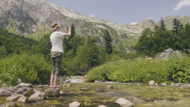 관광 남자 하 고 여행에 휴대 전화 사진 산과 강 풍경 — 비디오