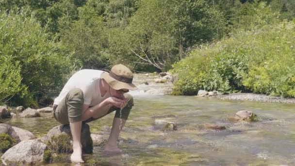 Žíznivý muž pitnou vodou z ruky při horské turistiky — Stock video