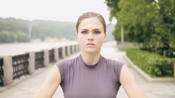 Портрет молодої жінки, що тренується з розширювачем фітнесу в літньому парку — стокове відео
