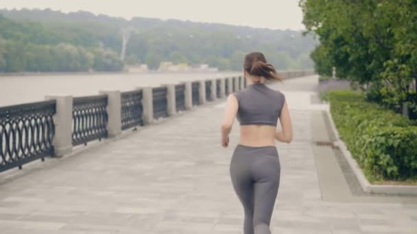 Idrottsman kvinna jogga på morgonen utbildning i sommaren park. Idrott och aktiv livsstil — Stockvideo