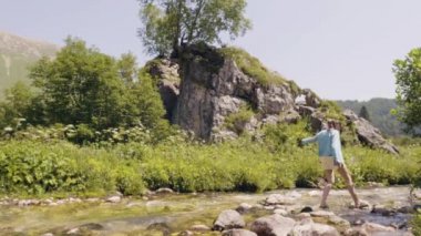 Kadın taş'a nehir çapraz. Turist kadın adım akan nehir içinde taşlar üzerinde