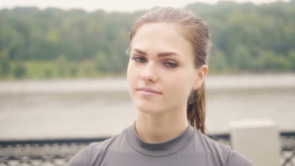 Face beautiful woman smiling and waving hand into camera outdoor. — Stock Video