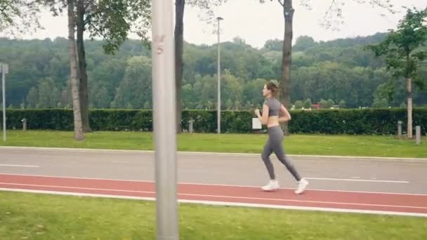 Young woman runner training in summer park. Sport and fitness training — Stock Video