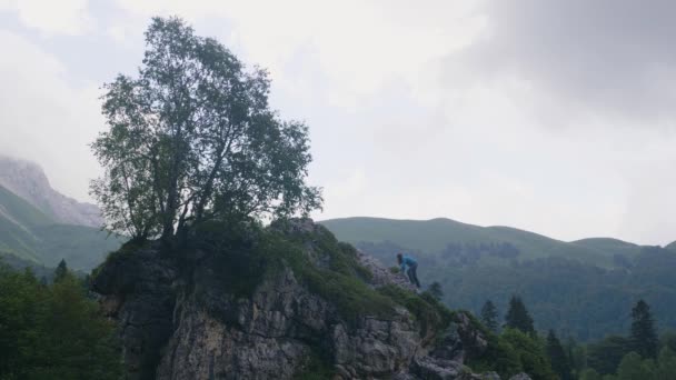 Mladá žena lezení na vrcholu hory a těší přírodní krajina — Stock video