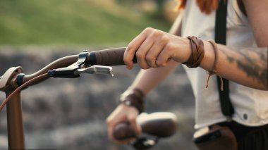 Bisiklete binmek yanında şehir yolda yürüyen kadın bacaklar. Kadın ayak ve bisiklet tekerleği