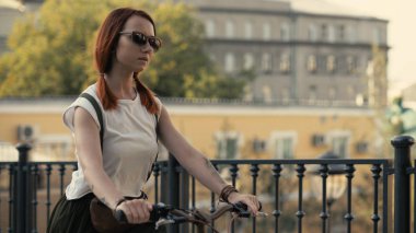 Şehir Parkı üzerinde bisiklet sürme yanında yürüyen kadın. Kadın Bisiklet park