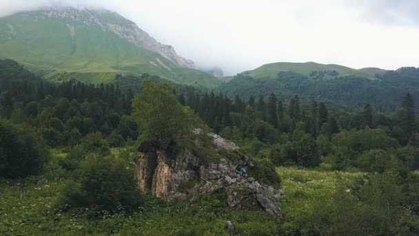 Jeune femme grimpant sur la vue aérienne de la montagne. Vue sur drone femme sur falaise pierreuse — Video