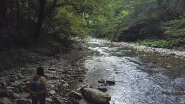 Taşlı yaz ormandaki nehir kıyısında yürürken sırt çantası kadınla robot görünümü