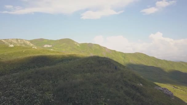 Belos caminhantes paisagistas caminhando no prado verde na vista aérea da montanha — Vídeo de Stock