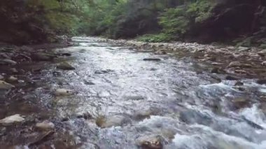 Yukarıdan çekim taşlar drone üzerinde hızlı bir şekilde akan nehir akarsu