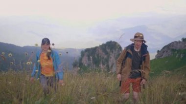 Dağ gezisi sırasında çayır üzerinde yürüyen turist insanlar. Dağ Vadisi üzerinde yürüme yürüyüş yapanlar. Yaz trekking ve aktif yaşam tarzı