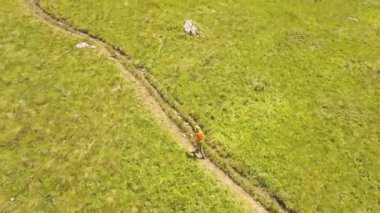 Genç adam dağ yayla hava görünümünü yaz çayır üzerinde çalışan