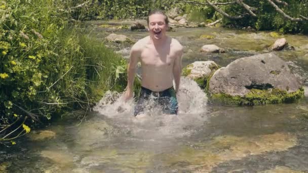 Uomo felice immerso e spruzzata d'acqua dalla sorgente di montagna. L'uomo che fa il bagno nel fiume — Video Stock