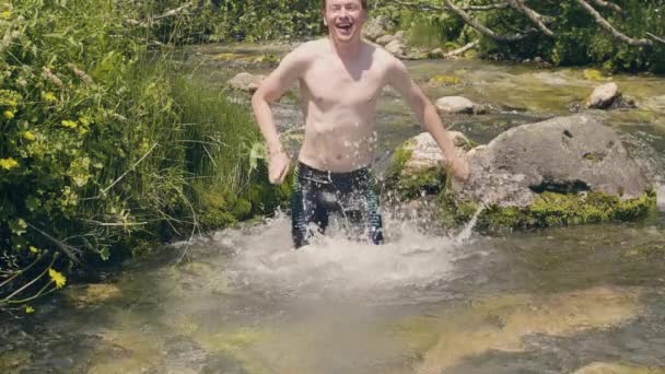 Homem sorridente mergulhando e tomando banho na água fria do rio no dia de verão. Movimento lento — Vídeo de Stock