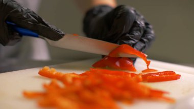 Sebze salatası yemek pişirmek için parçalar halinde kırmızı Bulgar biber kesme Şef eller