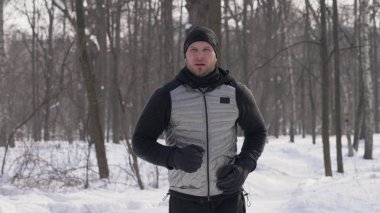 Sabah koşu sırasında kış şehir Park'ta koşan spor adam. Kış ormanda koşu