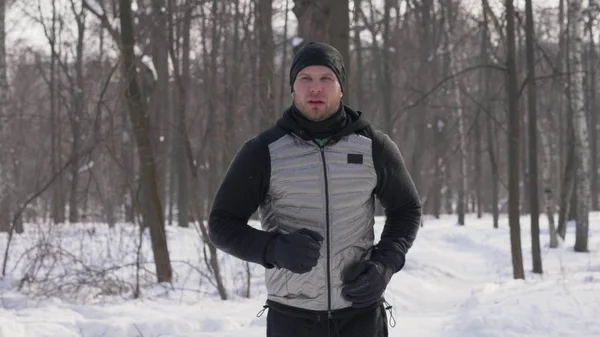 Sabah koşu sırasında kış şehir Park'ta koşan spor adam. Kış ormanda koşu