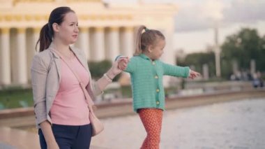 Genç Anne oynak kızıyla yaz park yaz çeşme kenarında yürüyüş