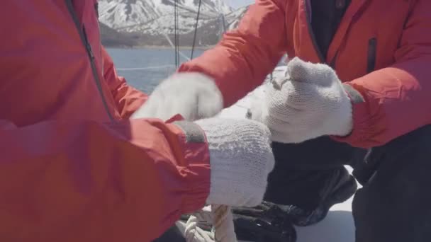 Manos masculinas de marinero hombre atar nudos de mar en las cuerdas a bordo de yate de vela — Vídeo de stock