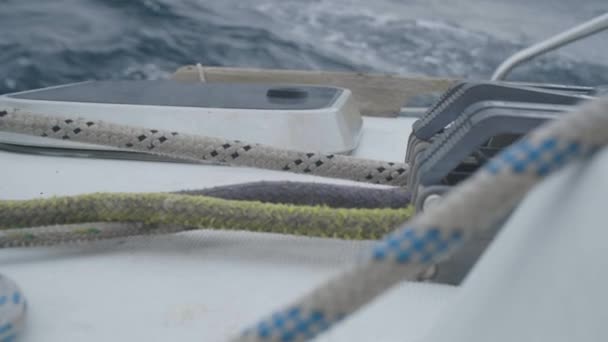 Мужские руки яхтсмена тянут и раскатывают веревки на борту парусной яхты вблизи — стоковое видео